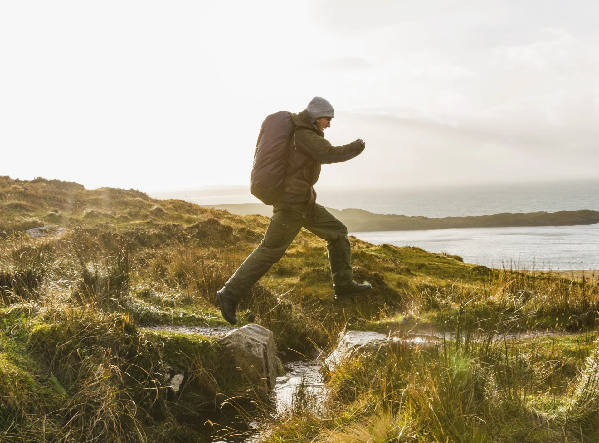 a man with a rucksack and winter clothing leaping 2026 01 09 10 42 01 utc