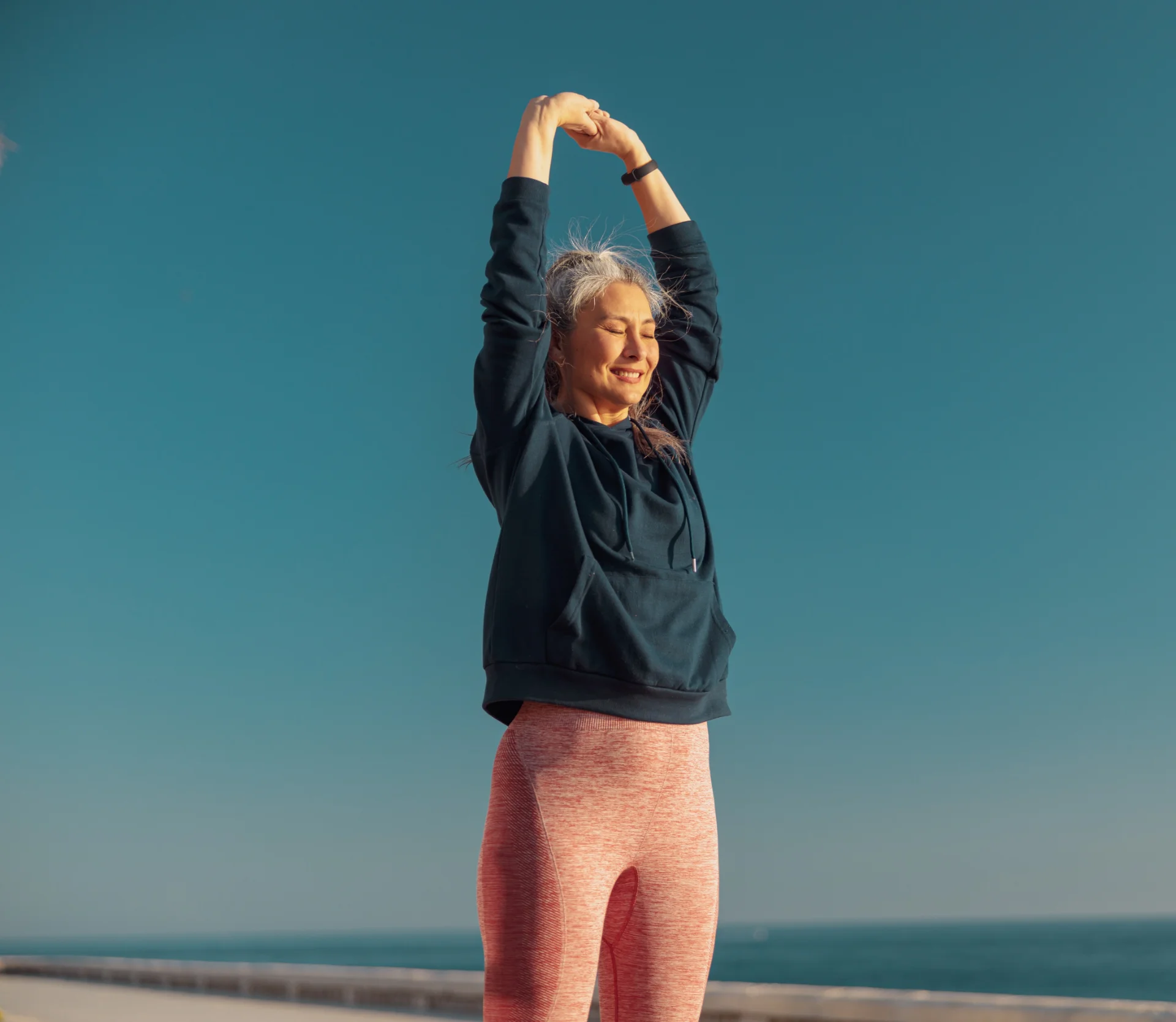 woman stretching arms on coastal walkway 2026 03 10 01 09 23 utc